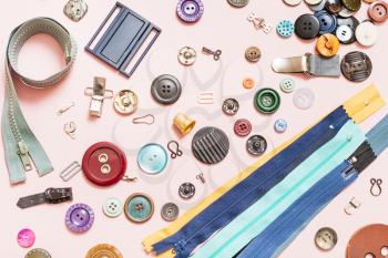 top view of set of various sewing items on pink background