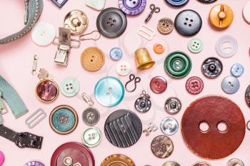 top view of many various sewing items on pink background