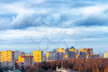 dark blue clouds over apartment buildings in Moscow city in spring evening