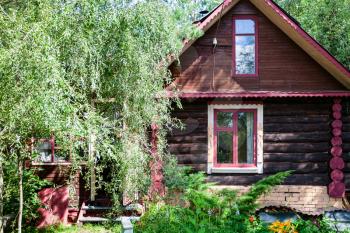 facade of russian wooden log house on sunny summer day
