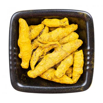 top view of Turmeric (Curcuma) roots in black bowl isolated on white background