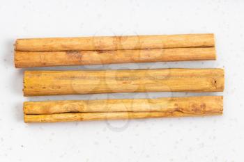 top view of three sticks of alba premium ceylon cinnamon close up on gray ceramic plate