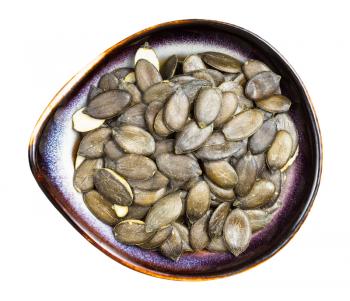 top view of styrian pumpkin seeds in ceramic bowl isolated on white background