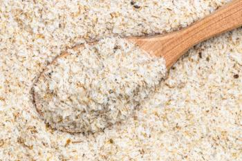 top view of wood spoon with psyllium husk close up on pile of sugar