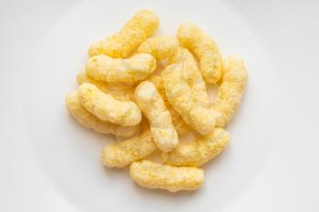 top view of pile of corn puffs on white plate