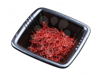 crocus saffron threads in black bowl isolated on white background