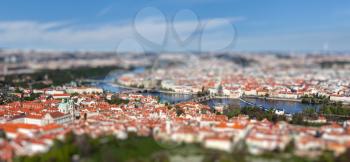 Aerial view of Charles Bridge over Vltava river and Old city from Petrin hill Observation Tower with tilt shift toy effect shallow depth of field. Prague, Czech Republic