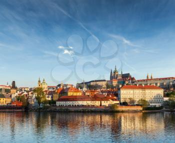 View Gradchany (Prague Castle) and St. Vitus Cathedral over Vltava river on sunset