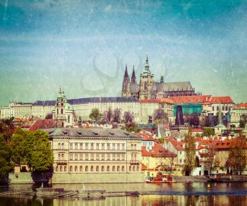 Vintage retro hipster style travel image of Charles bridge over Vltava river and Gradchany (Prague Castle) and St. Vitus Cathedral with grunge texture overlaid