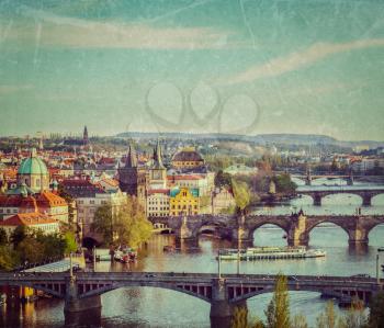 Vintage retro hipster style travel image of travel Prague concept background - elevated view of bridges over Vltava river from Letna Park with grunge texture overlaid. Prague, Czech Republic