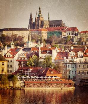 Vintage retro hipster style travel image of Mala Strana and  Prague castle over Vltava river with grunge texture overlaid. Prague, Czech Republic
