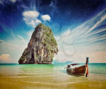 Retro vintage hipster style image of tropical vacation holiday beach concept - Long tail boat on tropical beach, Krabi, Thailand with grunge texture overlaid