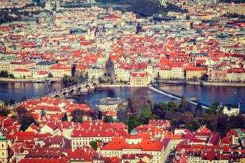 Vintage retro hipster style travel image of aerial view of Charles Bridge over Vltava river and Old city from Petrin hill Observation Tower. Prague, Czech Republic