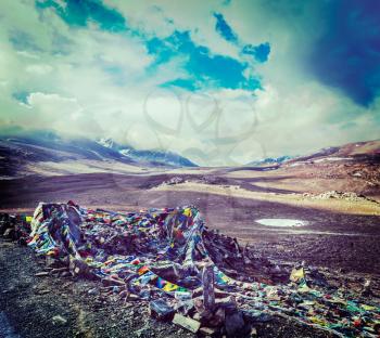 Vintage retro effect filtered hipster style travel image of Buddhist prayer flags lungta on Baralacha La pass on Manali-Leh highway in Himalayas. Himachal Pradesh, India