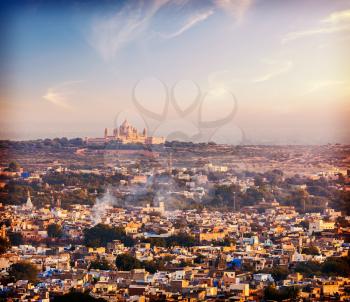 Vintage retro hiptster style photo of aerial view of Jodhpur - the Blue city - with Umaid Bhawan Palace on sunset. View from Mehrangarh Fort.  Jodphur, Rajasthan, India