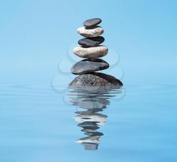 Zen meditation background -  balanced stones stack in water with reflection