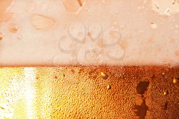 Beer foam in cool glass taken closeup as background.