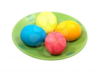 Multicolored easter eggs on green plate isolated on white background.