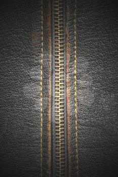 Metal zipper on a black leather taken closeup as background. 