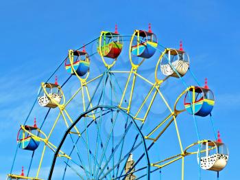 Multicolored carousel against blue sky.