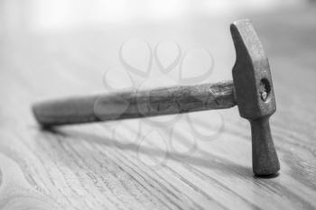 Old hammer on a wooden table taken closeup. 