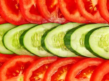 Slices of tomatoes and cucumbers taken closeup as background.