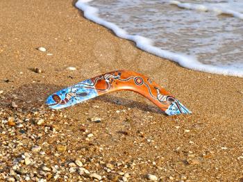 Colorful boomerang on a sandy beach.