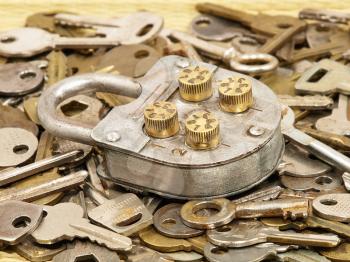 Oldl lock on a metal keys background.