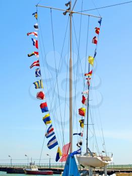 Set of the sea alarm flags on a mast on the pier.