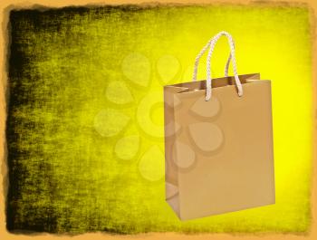 Empty golden shopping bag on a yellow grungy background with frame border.