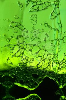Cool beer foam on green bottle taken closeup suitable as abstract background.Digitally generated image.