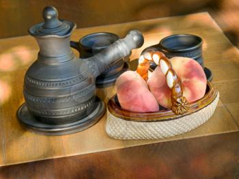 Coffee set and ceramic vase with peaches on a table.