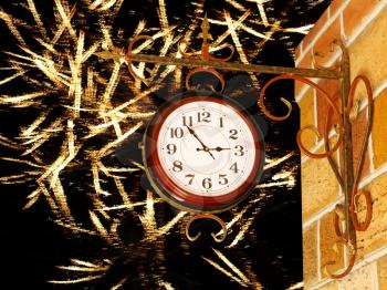 Vintage clock and yellow brick wall on glowing firework background.
