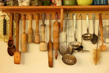 Wooden and metal kitchen ware hanging on the wall taken closeup.