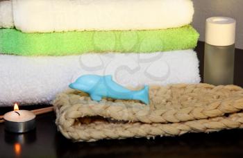 Towel pile with bast and dolphin form soap in the shower.