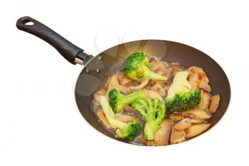 Roasted mushrooms and broccoli in frying pan isolated on white background.
