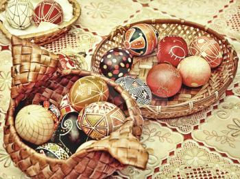 Multicolored easter eggs in straw pots on a table.Retro style toned image.