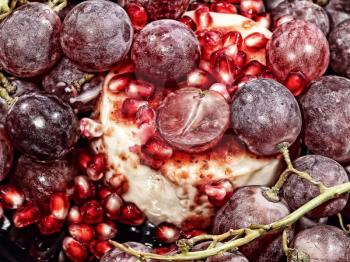 Sweet dessert with fresh pomegranate grains and grapes berries. Digitally altered and toned image.