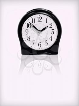 Alarm clock with reflection on white background.Purple toned image.