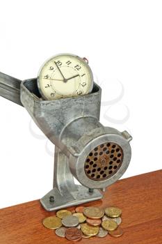 Alarm clock in manual meat grinder and coins on wooden table.Money concept.