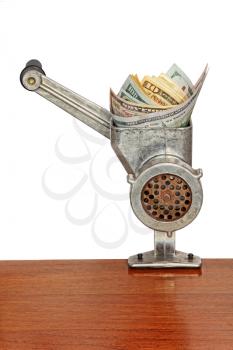 Money concept with dollar banknotes in meat grinder on wooden table and white background.