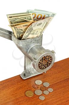 Dollar banknotes in meat grinder and coins on wooden table.Money concept.