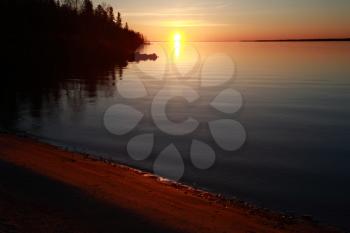 Reflected sunrise along shore of Lake Winnipeg