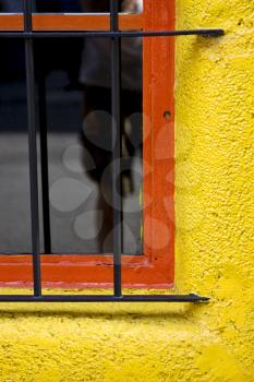  old red window and iron grate in a yellow wall in the centre of buenos aires argentina