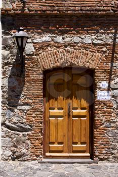 brown wood old door and a street lamp in the centre of colonia del sacramento uruguay