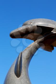   oman musact  old statue of dolphin in the sea and clear sky