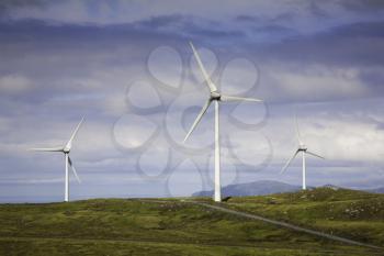 Modern windmills on a green hill
