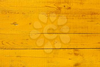 Detail of wooden fence. Four horizontal boards freshly painted  in bright yellow