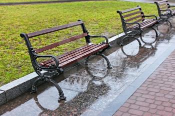 Row of wet benches after the rain in the city square in Lviv, Ukraine