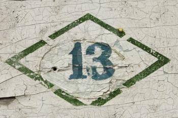 Number thirteen. Sign, put paint on the old wooden painted surface